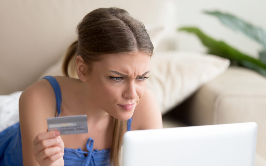 Confused woman having problem with credit card making online payment