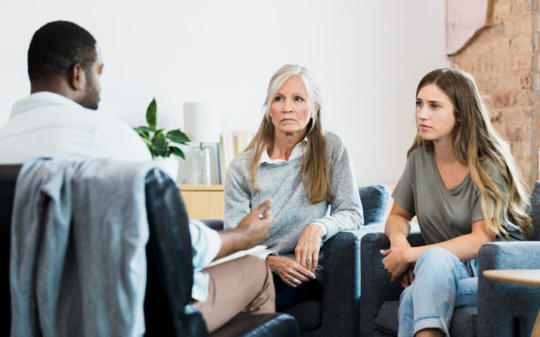 Therapist gestures while advising serious mother and daughter