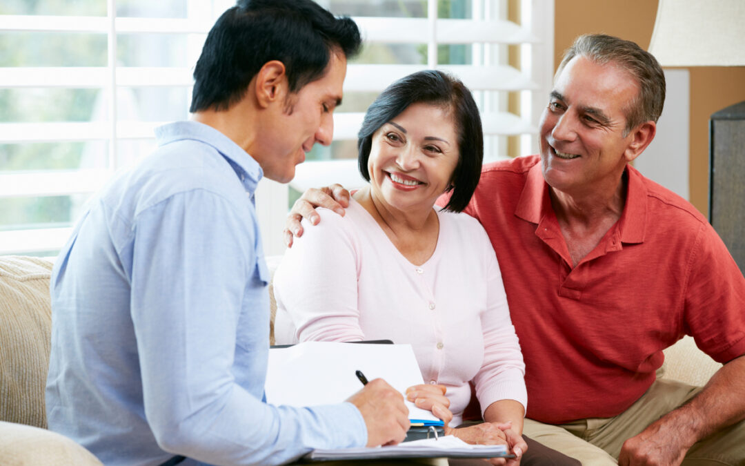 A financial advisor talking to an elderly couple in home